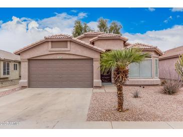 Charming single-story home with a two-car garage and a desert-landscaped yard, complete with a mature palm tree at 2704 E Anderson Dr, Phoenix, AZ 85032