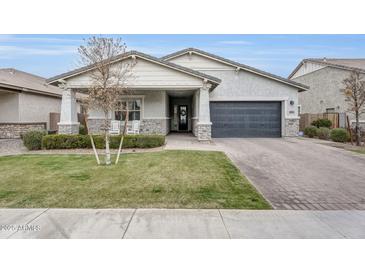 Charming single-story home featuring a well-manicured lawn and stone accents at 3504 E Boot Track Trl, Gilbert, AZ 85296