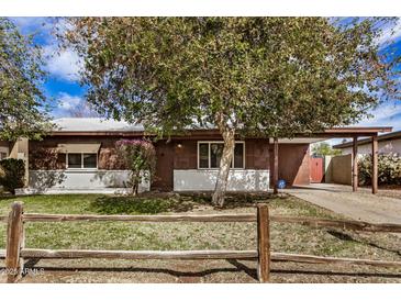 Charming single-story home featuring a well-manicured front yard and a rustic wooden fence at 6720 W Medlock Dr, Glendale, AZ 85303