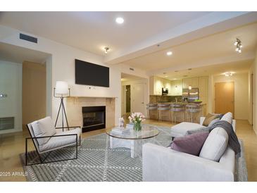 Bright living room featuring a fireplace, kitchen and comfortable seating area at 7147 E Rancho Vista Dr # 3010, Scottsdale, AZ 85251