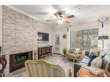 Inviting living room with a stone fireplace and comfortable seating at 7575 E Indian Bend Rd # 1036, Scottsdale, AZ 85250