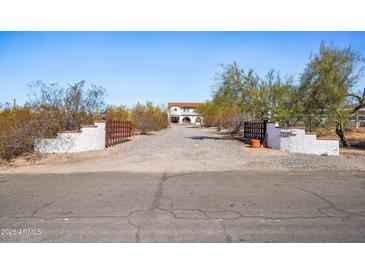 Gated driveway leading to beautiful estate with mature desert landscaping in a rural setting at 7650 E Culver St, Mesa, AZ 85207