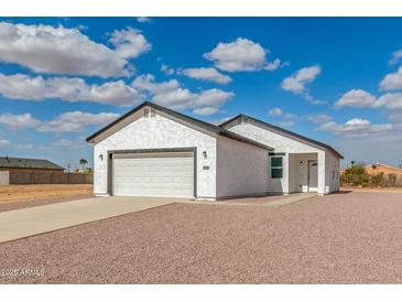 Charming single Gathering home with attached two car garage and neutral colored stucco at 9504 W Century Dr, Arizona City, AZ 85123