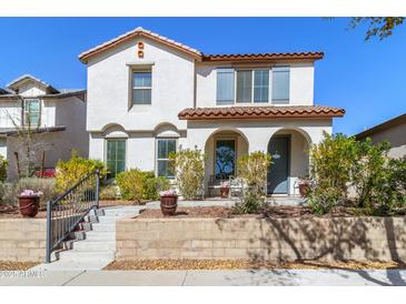 Charming two-story home with a red tile roof, stucco walls, arched entry, and landscaped front yard at 20728 W Legend Trl, Buckeye, AZ 85396