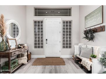 Bright foyer with a rustic rug, decorative furniture, and glass block windows, creating an inviting atmosphere at 30427 W Vale Dr, Buckeye, AZ 85396