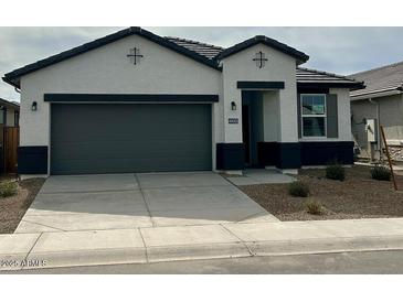 Charming single-story home featuring a two-car garage, neutral stucco exterior, and dark trim accents at 40005 W Hillman Dr, Maricopa, AZ 85138