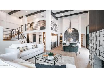 Bright, modern living room with soaring ceilings, black beams, and comfortable white sofas at 4434 E Camelback Rd # 128, Phoenix, AZ 85018