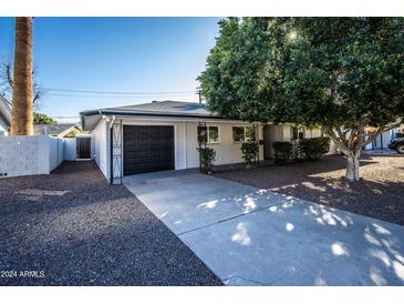 Charming single-story home featuring a driveway, well-maintained landscaping and a black garage door at 4729 N 24Th St, Phoenix, AZ 85016