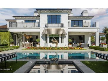 Stunning backyard pool featuring a unique water feature and immaculate landscaping in a modern luxury home at 5915 E Calle Del Sud --, Phoenix, AZ 85018