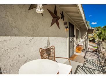 Cozy front porch seating area with rustic decor and a welcoming entrance at 1050 at 1050 N 84Th Pl, Scottsdale, AZ 85257