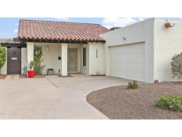 Charming front exterior view of a home with a red tile roof, white stucco walls, and a well-manicured yard at 1216 E Rancho Dr, Phoenix, AZ 85014