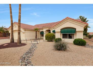 Inviting single-story home featuring a desert-friendly landscape, red tile roof, and charming curb appeal at 16004 W Falcon Ridge Dr, Sun City West, AZ 85375