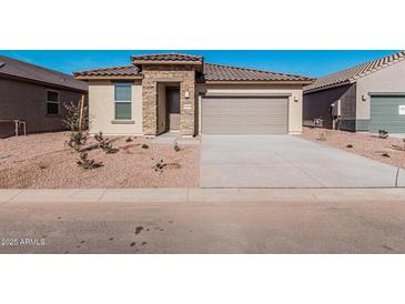 Charming single-story home featuring a stone entrance and a two-car garage with desert landscaping at 20660 N Confetti Ct, Maricopa, AZ 85138