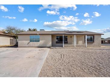 Inviting single-story home with a classic desert landscape and a covered porch entrance at 2215 N 58Th Dr, Phoenix, AZ 85035