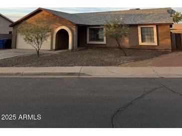 Single-story house featuring neutral stucco, a gray roof, and desert landscaping at 304 E Madison St, Avondale, AZ 85323