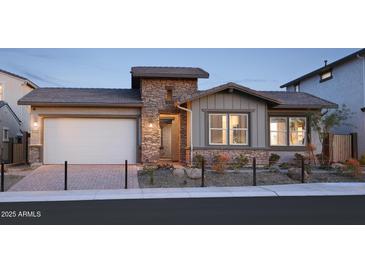 Charming single-Gathering home featuring a stone facade, two-car garage, and well-maintained landscaping at 44409 N 43Rd Dr, Phoenix, AZ 85087