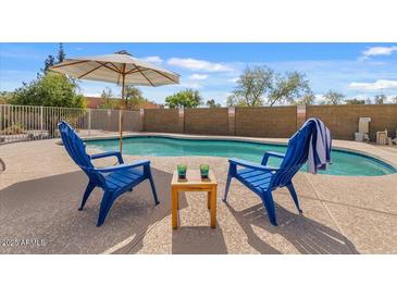 Backyard pool featuring patio furniture and privacy wall, perfect for outdoor relaxation at 6915 E Gary Cir, Mesa, AZ 85207