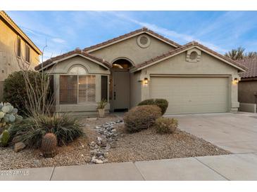 Charming single-story home featuring well-maintained landscaping, a tile roof and neutral exterior color palette at 10215 E Hillery Dr, Scottsdale, AZ 85255