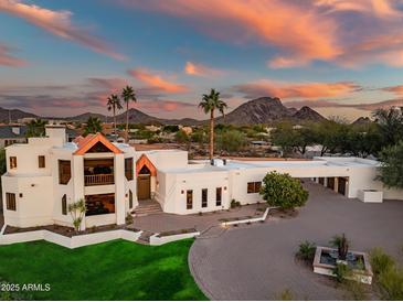 Stunning aerial view of a modern home showcasing its unique architecture and desert landscape at sunset at 10301 N 128Th St, Scottsdale, AZ 85259