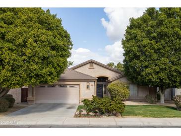 Charming single-story home with desert landscaping, mature trees, and a two-car garage at 1054 W Park Ave, Gilbert, AZ 85233