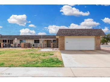 Charming home featuring a well-maintained lawn and an attached two-car garage at 11139 W Cameo Dr, Sun City, AZ 85351