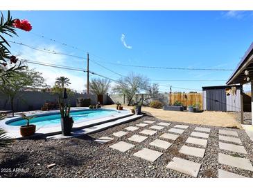 Backyard oasis with a sparkling pool, mature landscaping, and tranquil atmosphere at 1515 E Sunnyslope Ln, Phoenix, AZ 85020