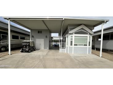 Charming exterior featuring gray siding, covered parking, and neat landscaping at 17200 W Bell Rd # 958, Surprise, AZ 85374