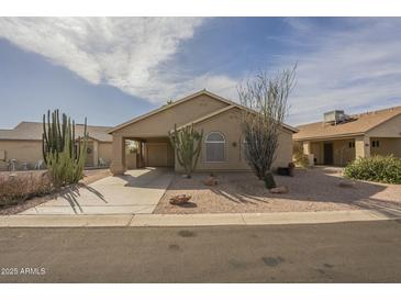 Charming desert home with a spacious driveway and attached carport, framed by native cacti and desert landscaping at 1793 E Desert Inn Dr, Chandler, AZ 85249