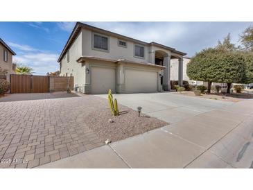 Charming home featuring a three-car garage, desert landscaping, and inviting curb appeal at 22050 N Balboa Dr, Maricopa, AZ 85138