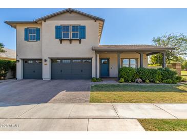 Charming two-story home with blue shutters, gray garage doors and a quaint front porch at 3623 E Arabian Dr, Gilbert, AZ 85296