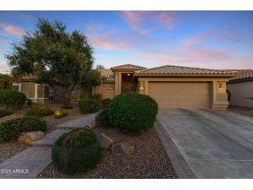 Beautiful home showcasing sunset colors, manicured landscaping, and a spacious two-car garage at 3711 N 162Nd Ln, Goodyear, AZ 85395