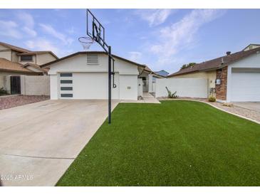 Charming home featuring a pristine front yard, well-kept lawn, and a basketball hoop for added curb appeal at 4233 E Covina St, Mesa, AZ 85205