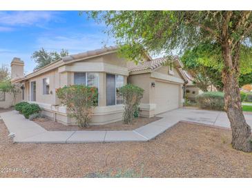 Charming single-story home featuring a tile roof, bay window and a two-car garage, all set amidst mature landscaping at 473 S Ash St, Gilbert, AZ 85233