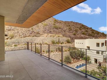 Expansive outdoor balcony featuring desert views with modern railing and a wood plank ceiling at 5000 N Camelback Ridge Dr # 409, Scottsdale, AZ 85251