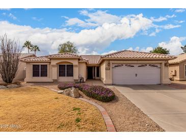 Charming single-story home with a well-manicured lawn and two car garage at 6401 W Irma Ln, Glendale, AZ 85308