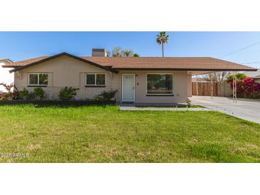 Charming single-story home featuring a well-maintained lawn and a convenient covered carport at 699 W Shannon St, Chandler, AZ 85225