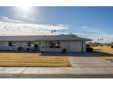 Charming single-story home with light brick, desert landscaping, and an attached two-car garage at 10019 W Shasta Dr, Sun City, AZ 85351