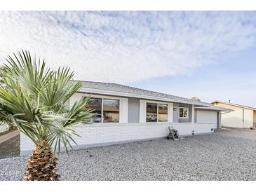 Charming single-story home featuring a well-maintained front yard, white brick facade, and inviting curb appeal at 10407 W Mission Ln, Sun City, AZ 85351