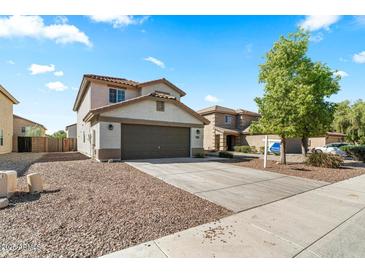 Two-story home featuring a two-car garage, desert landscaping, and a 'For Sale' sign on a sunny day at 1655 W Wilson Ave, Coolidge, AZ 85128