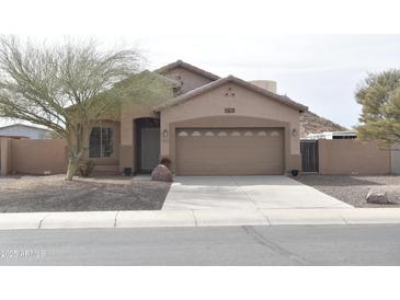 Charming single-story home with a two-car garage, desert landscaping, and a neutral color palette at 1813 N Lewis Pl, Casa Grande, AZ 85122