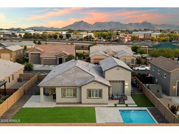 Stunning aerial view of home featuring a backyard pool and lush green lawn with mountain views at 20954 E Camacho Ct, Queen Creek, AZ 85142