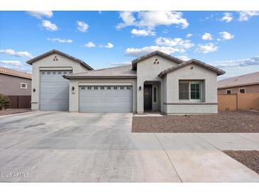 Charming single-story home boasts a three-car garage, manicured landscaping, and inviting curb appeal at 20954 E Camacho Ct, Queen Creek, AZ 85142