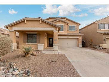 Inviting two-story home featuring a well-maintained yard and a welcoming covered entryway at 21629 N Dietz Dr, Maricopa, AZ 85138