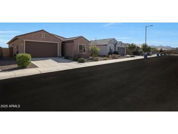 Charming single-story home with well-maintained landscaping and a two-car garage on a sunny day at 21889 N 259Th Ave, Buckeye, AZ 85396