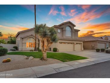 Charming two-story home featuring a well-manicured lawn and a three-car garage at 2419 E Goldenrod St, Phoenix, AZ 85048