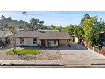 Charming single-story home with gravel landscaping, desert flora, and a spacious driveway at 2525 E Nisbet Rd, Phoenix, AZ 85032