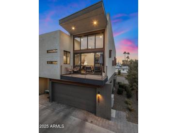 Contemporary home featuring a balcony and a ground-level garage, set against a vibrant sunset sky at 3106 N 70Th St # 2003, Scottsdale, AZ 85251