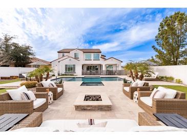 Inviting backyard oasis with a sparkling pool, spa, fire pit, and stylish patio furniture for outdoor living at 5139 S Bridal Vail Dr, Gilbert, AZ 85298