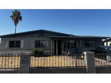 Single story home with a dark car parked in the driveway and a fence out front at 6222 S 18Th Ave, Phoenix, AZ 85041