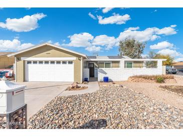 Charming front exterior featuring a well-maintained yard and a two-car garage with a white door at 790 N Meadows Dr, Chandler, AZ 85224